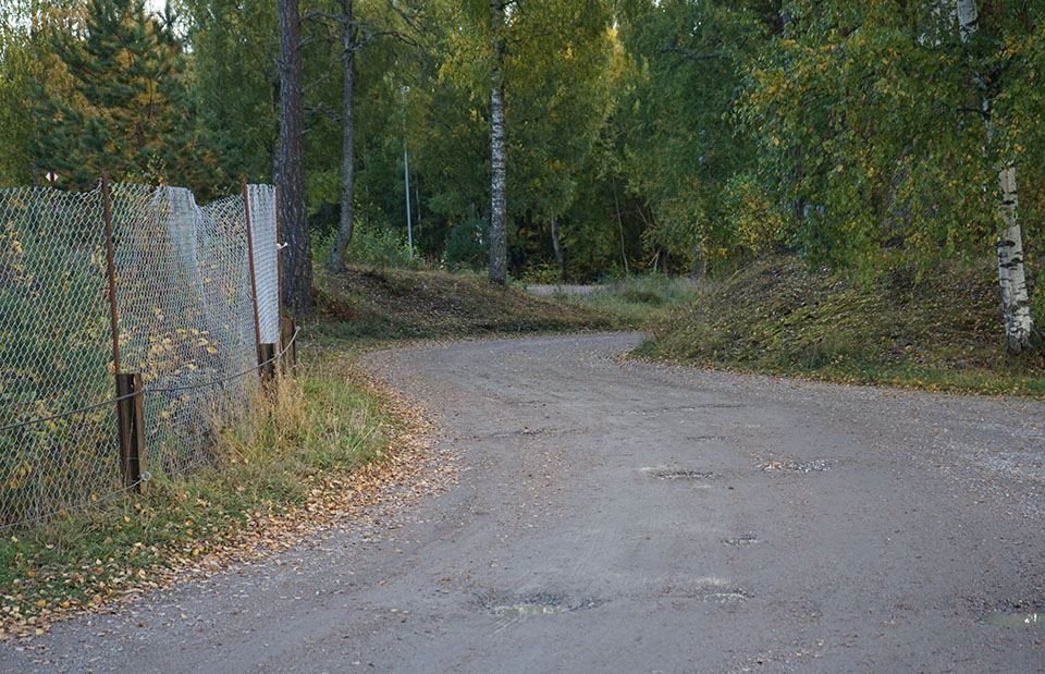 Foto på grusvägen södra infarten till Silvergruvan sett i riktning mot Västeråsleden